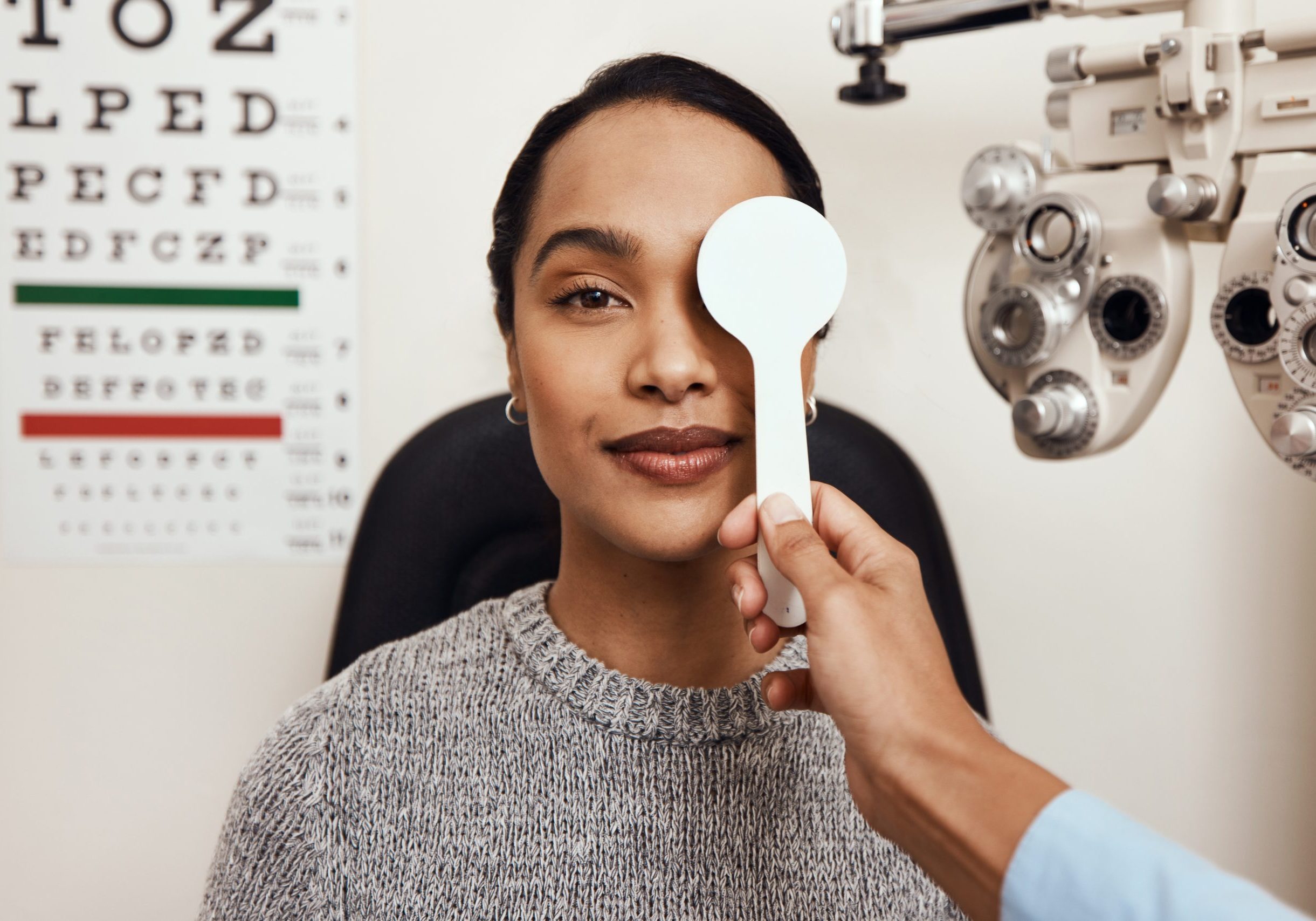 Shot of an optometrist covering her patient’s eyes with an occluder during an eye exam